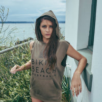 Model standing on a tarrus, having Surf Sleeveless Pullover Jumper in Olive, with writing text of Bikini Beach Australia