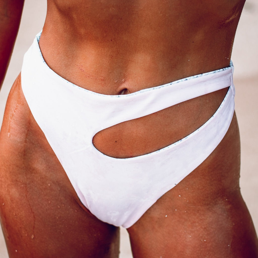 Model  having Reversed white Diamond Bay Bikini Bottom in White -Angled Cut out Design - High waist cheeky thong cut bottom 