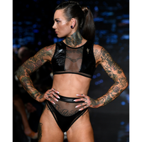 Model having Hamilton Island Bikini in Liquid Black Reversible - high neck mesh detailing, high waist mesh detailing bottom - regular bum covering bottom, Tattooed arms and neck, pony tail tied hair