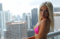 Model standing on some sky scrapper Taurus, having Pinky Beach Bikini